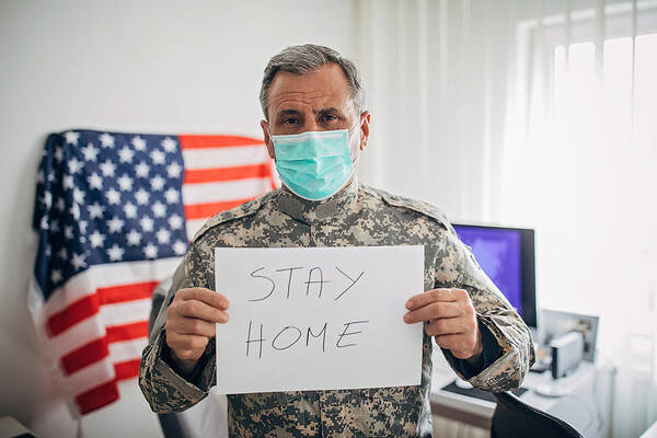 Working Art Print featuring the photograph Senior military soldier holding paper with message stay home by Hirurg