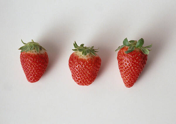 White Background Art Print featuring the photograph Three strawberries in a row, close-up, white background by Isabelle Rozenbaum & Frederic Cirou