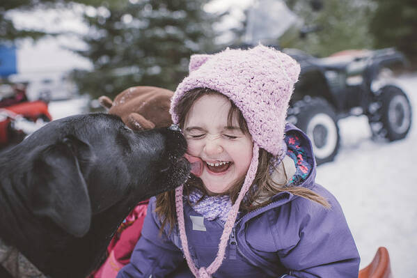 Pets Art Print featuring the photograph Young girl with dog in snowy landscape, dog licking girls face by Jenn Austin-Driver (Photography)