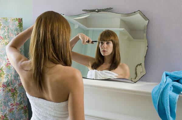 White People Art Print featuring the photograph Young woman wearing towel cutting fringe in mirror, rear view by Tara Moore