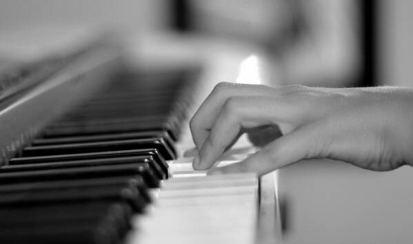 Playing Piano Art Print featuring the photograph Hand on piano keyboard by Serena King