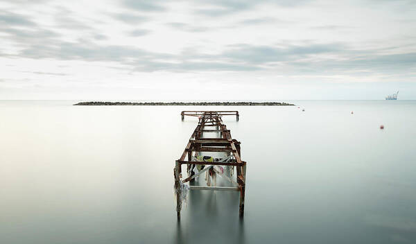 Jetty Art Print featuring the photograph Abandoned pier in the ocean. Long Exposure by Michalakis Ppalis