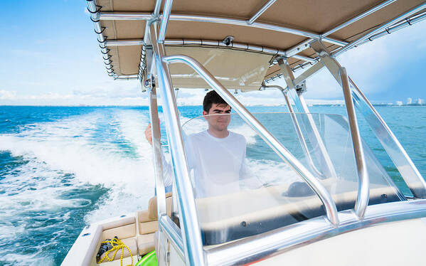 Tourboat Art Print featuring the photograph Teenager driving a boat by Thepalmer