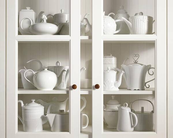 Indoors Art Print featuring the photograph Assorted Tea And Coffee Pots In A Glass Cupboard by Sivan Lewin