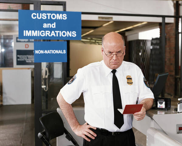 One Man Only Art Print featuring the photograph Passport Officer at Airport Security by Digital Vision.