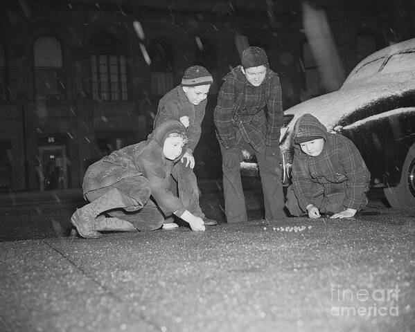 Child Art Print featuring the photograph Boys Play Marbles Under Falling Snow by Bettmann