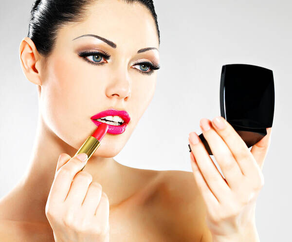 Eyelash Art Print featuring the photograph Beautiful woman applying pink lipstick on lips by ValuaVitaly