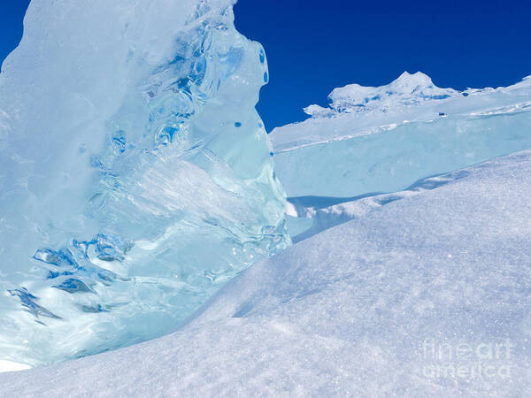 Abstract Art Print featuring the photograph Clear glacier ice chunks with snow and blue sky by Stephan Pietzko