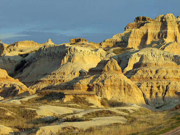Badlands National Park South Dakota Sd Parks North America American Badland Landscape Landscapes Sandstone Sandy Formations Formation Bad Lands Sky Skies Dusk Neutral Beige Colors Rugged Beauty Scenic Scenery Hiking Travel Vacation Destinations Blue Rapid City Brown Lighting Light Dimensional Dimensions Photography Photos Artistic Art Unique Rocky Rock Rocks James Melissa Peterson Nature Outdoor Wilderness Adventure Wall Buttes Pinnacles Grass Prairie Southwestern Dynamic Golden Hour Unusual Art Print featuring the photograph Dynamic Lighting by James Peterson