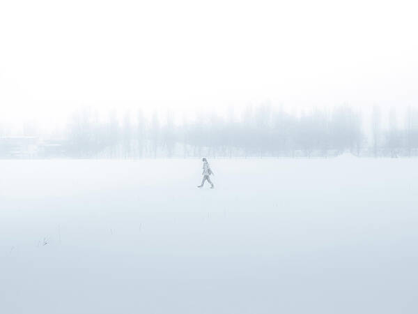 Scenics Art Print featuring the photograph Man Walking Through A Snowfield by Taketan