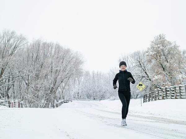 Mature Adult Art Print featuring the photograph Woman Running On Country Road In Winter by Tony Anderson