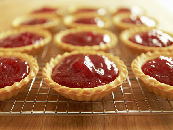 Baked Pastry Item Art Print featuring the photograph Close Up Of Jam Tarts Cooling On Wire #1 by Adam Gault