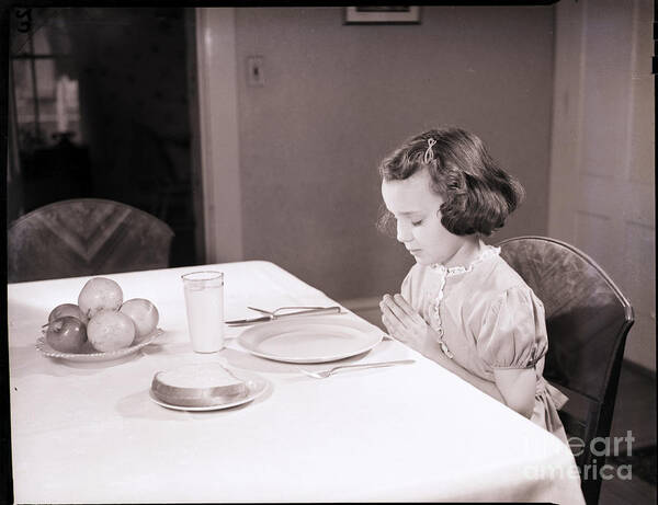 Child Art Print featuring the photograph Girl Praying At Table by Bettmann