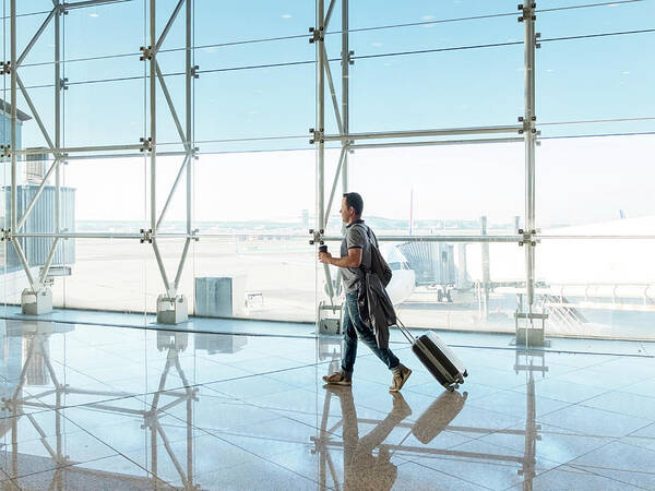 Aircraft Art Print featuring the photograph Man Walking With Suitcase At The Departure Hall Of The Airport. by Cavan Images