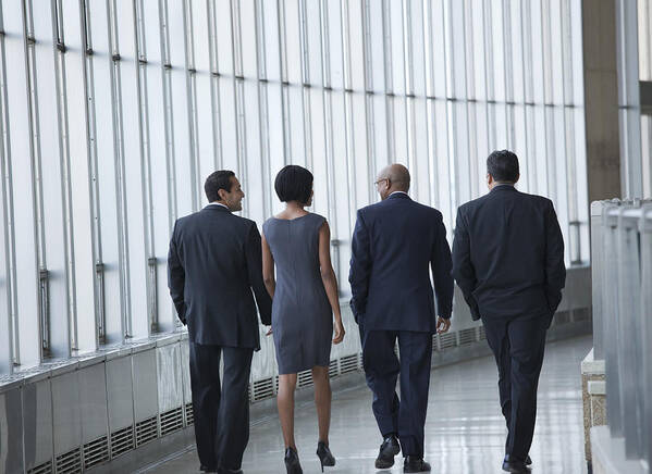 Young Men Art Print featuring the photograph Business people walking in corridor by Ariel Skelley