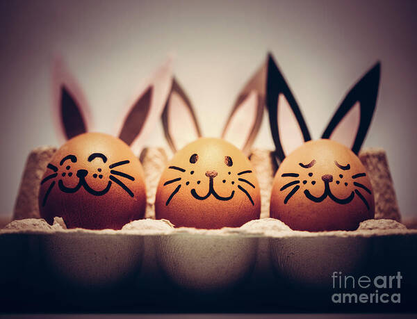 Easter Art Print featuring the photograph Three painted smiling Easter eggs bunnies sitting in an egg carton. by Michal Bednarek