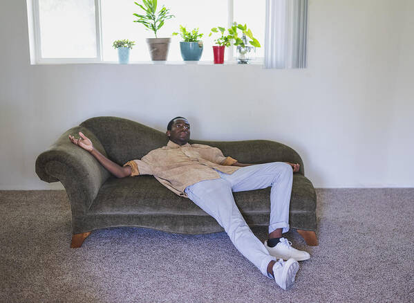 Handsome People Art Print featuring the photograph Young man lounging on sofa by Tony Anderson