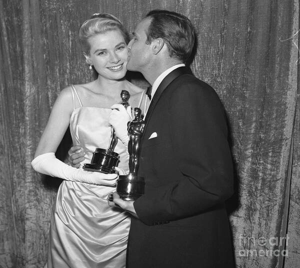 27th Annual Academy Awards Art Print featuring the photograph Marlon Brando Kissing Grace Kelly by Bettmann