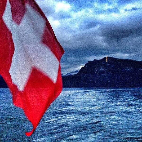 Beautiful Art Print featuring the photograph The Swiss Flag Flies Proud On A Stormy by Dave And Deb