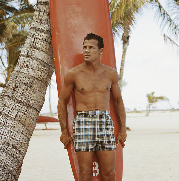 Three Quarter Length Art Print featuring the photograph Young Man Holding Surfboard On Beach by Tom Kelley Archive
