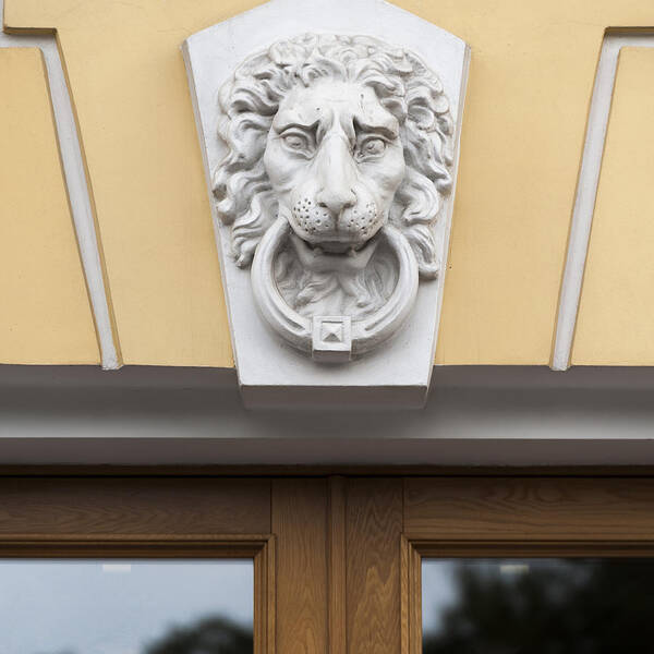 Art Art Print featuring the photograph Lions face statue carved on the wall of a building by Fotosearch