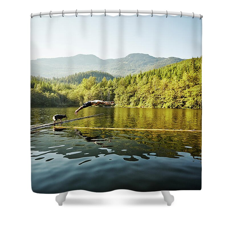 Pets Shower Curtain featuring the photograph Man Diving Off Log Into Alpine Lake Dog by Thomas Barwick