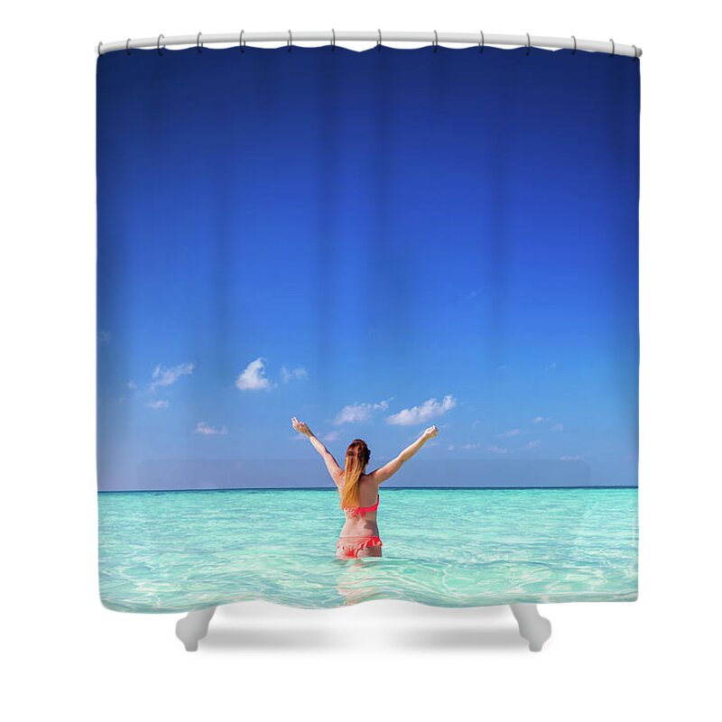 Woman Shower Curtain featuring the photograph Beautiful young woman standing in the ocean with hands raised. Maldives by Michal Bednarek