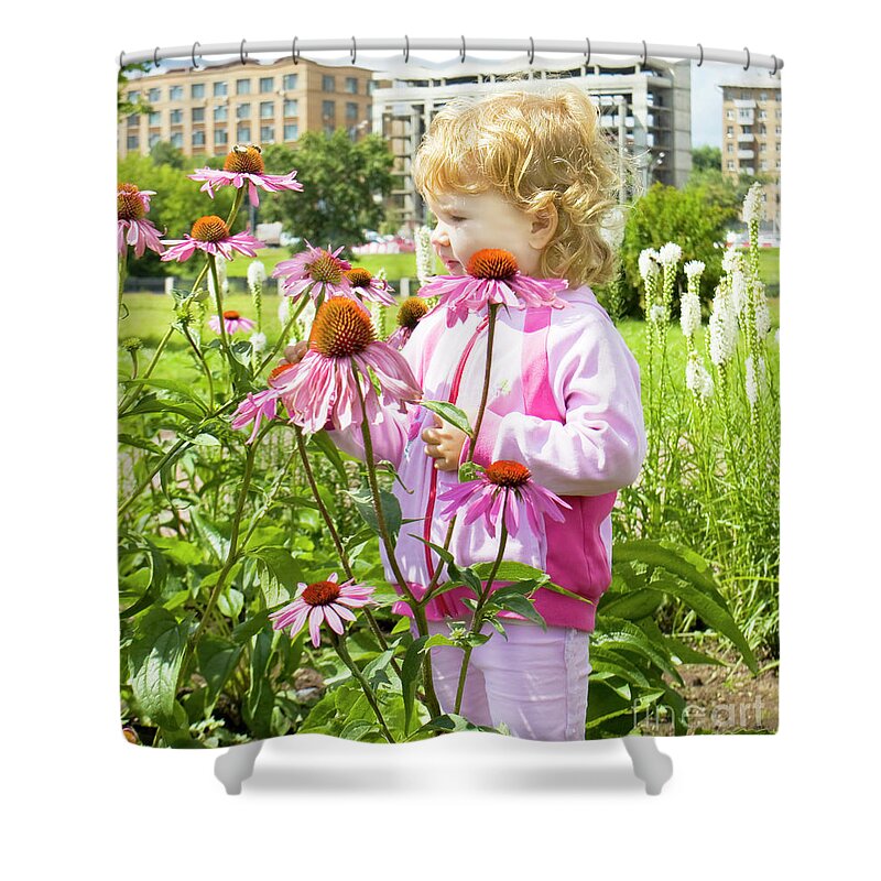 Child Shower Curtain featuring the photograph Little girl looking at flowers by Irina Afonskaya