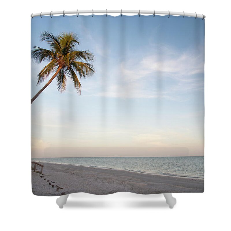 Outdoors Shower Curtain featuring the photograph A Palm Tree Leaning Over The Beach At by Driendl Group