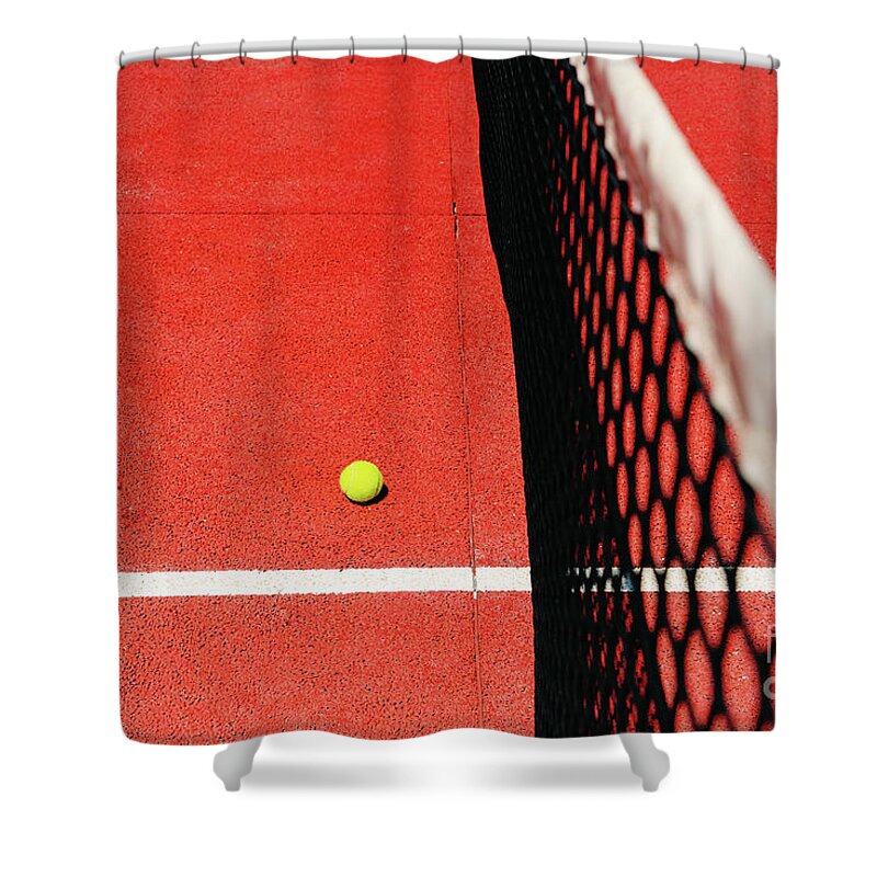 Ace Shower Curtain featuring the photograph A tennis ball on the textured floor of a red court near the net after losing a match point. by Joaquin Corbalan