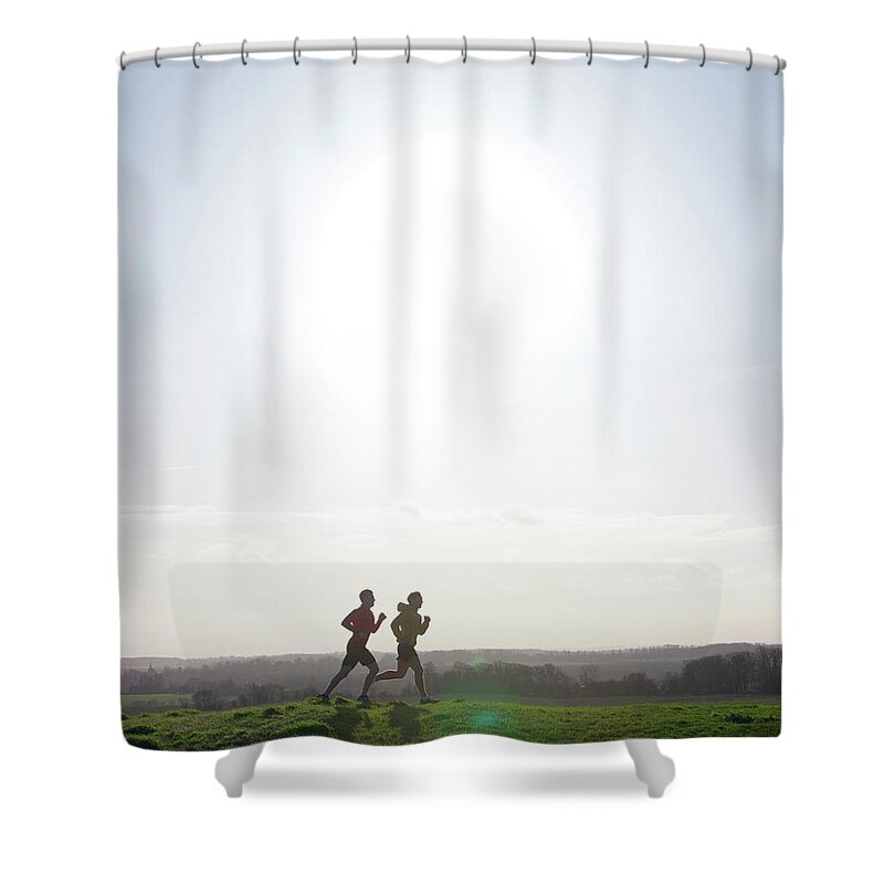 Young Men Shower Curtain featuring the photograph Two Joggers Running On Hill With Low by Tim Robberts
