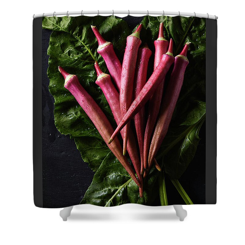 Red Okra Shower Curtain featuring the photograph Wet red okra on bed of chard by Cuisine at Home