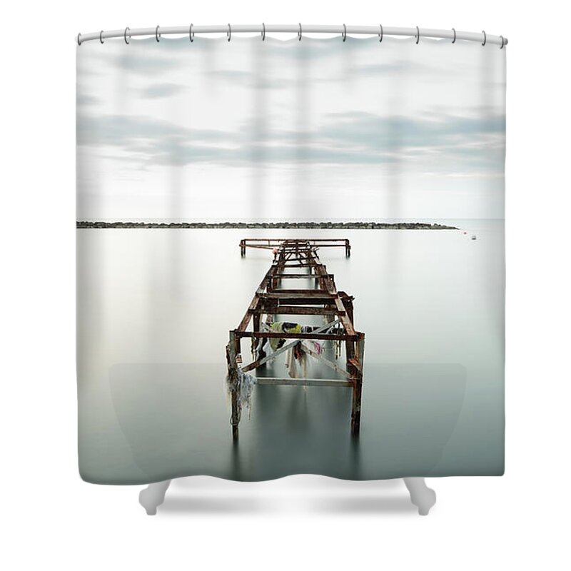 Jetty Shower Curtain featuring the photograph Abandoned pier in the ocean. Long Exposure by Michalakis Ppalis