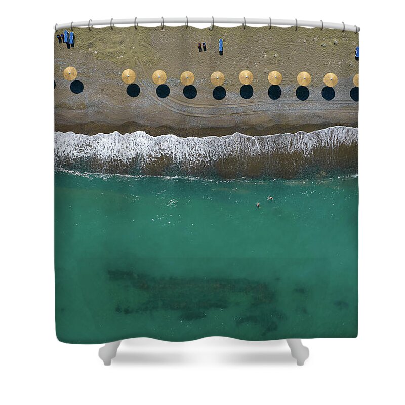  Beach Shower Curtain featuring the photograph Aerial view from a flying drone of beach umbrellas in a row on a by Michalakis Ppalis