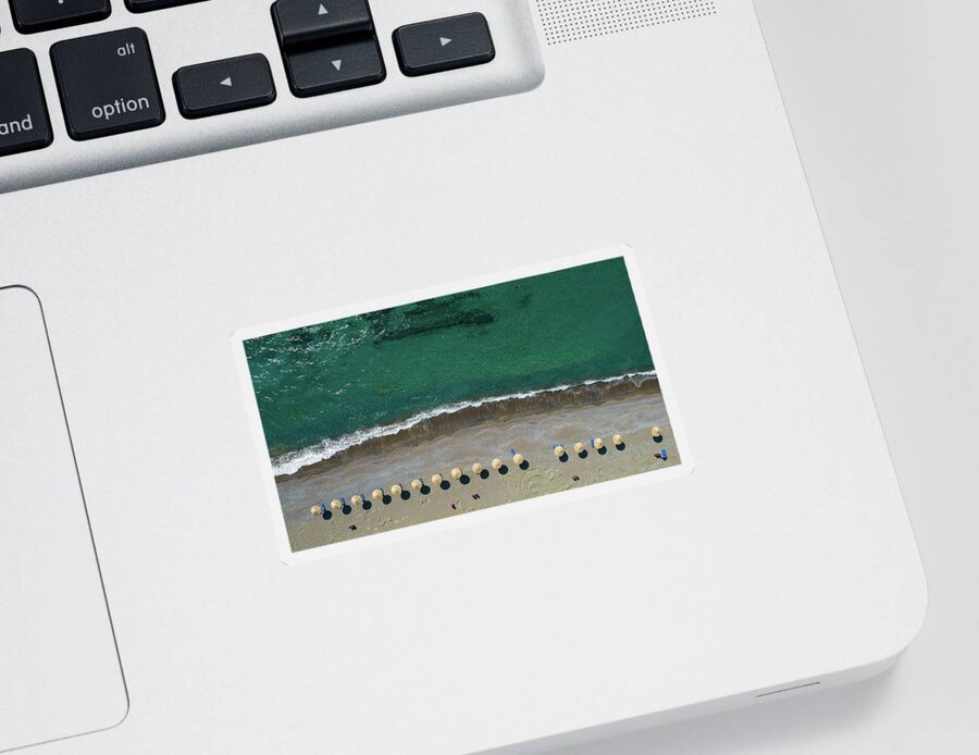 Summertime Sticker featuring the photograph Aerial view from a flying drone of beach umbrellas in a row on an empty beach with braking waves. by Michalakis Ppalis