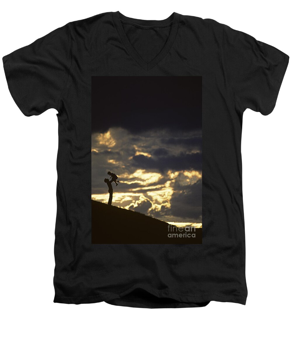 Silhouetted Men's V-Neck T-Shirt featuring the photograph Father holding daughter above his head along hillside silhouette by Jim Corwin