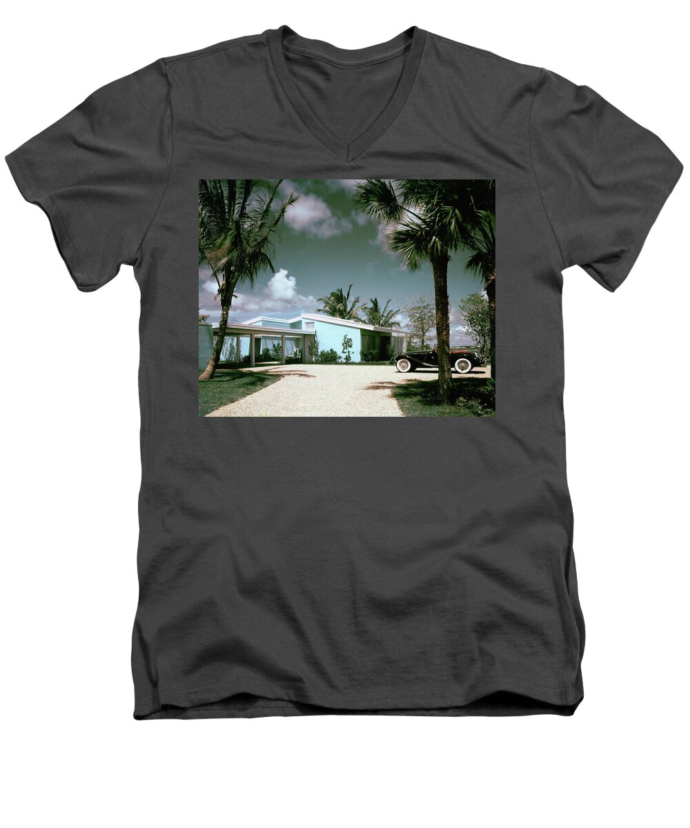 Nobodyoutdoorsdaytimehousedwellingdrivewayretroold-fashionedvintagevintage Cartransportationcarmotor Vehicleautomobilevehicletreemiamimiami-dade Countyfloridausanorth Americasouthern United Statesnorth American Atlantic Coastrobert M. Littlearchitecture #condenasthouse&gardenphotograph November 1st 1955 Men's V-Neck T-Shirt featuring the photograph A Vintage Car Parked Outside A Blue House by Tom Leonard