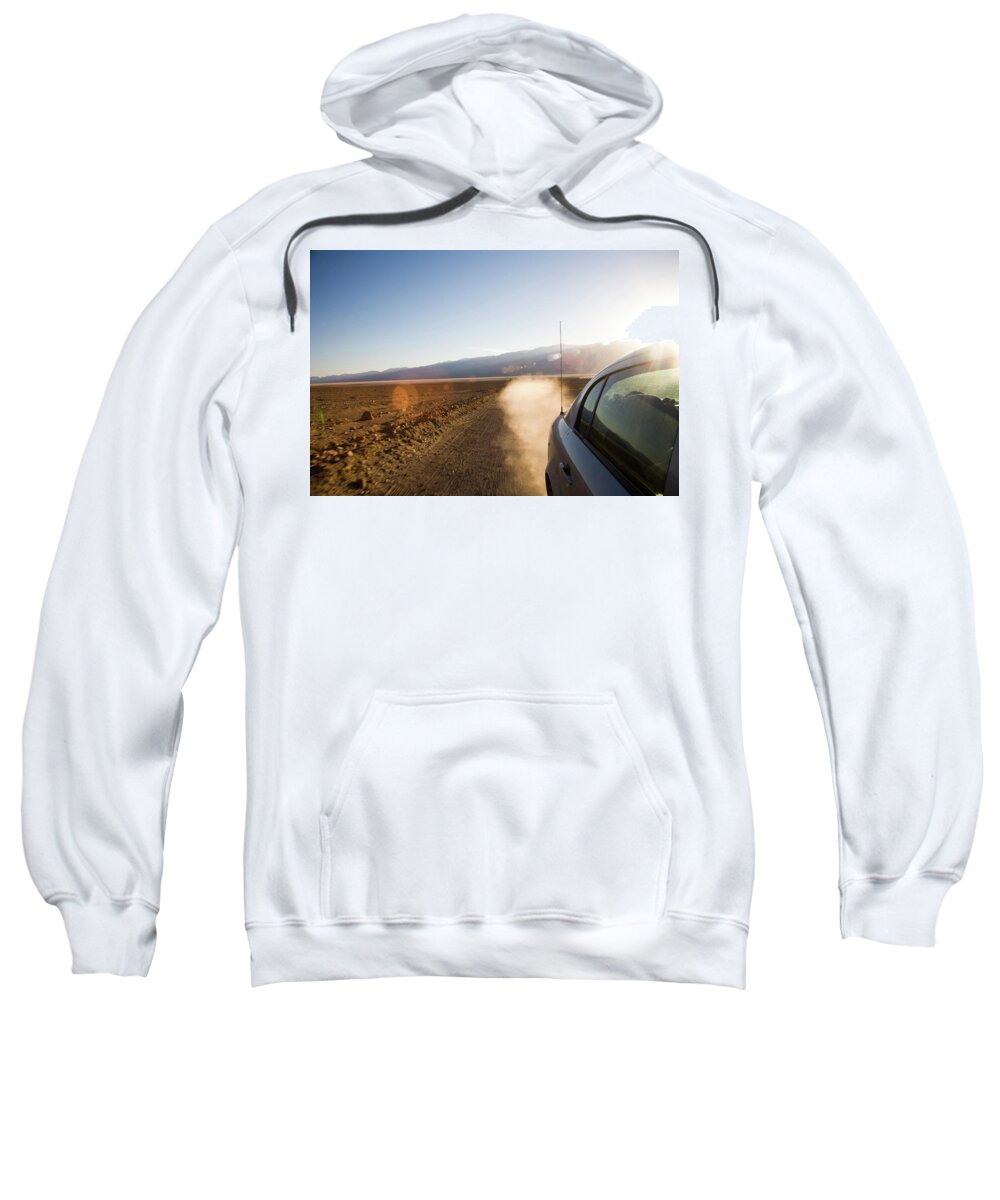 Adventure Sweatshirt featuring the photograph A Car Speeds Down A Sandy Road Leaving by Michael Hanson