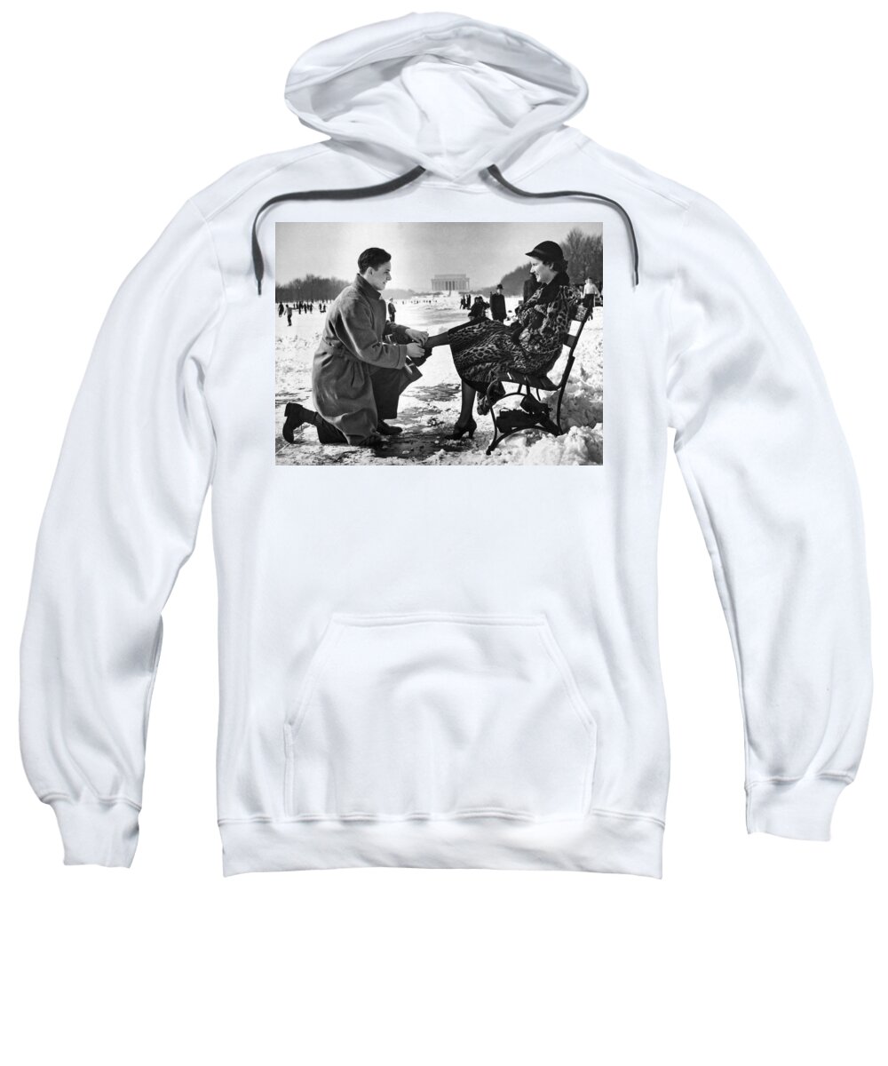 1936 Sweatshirt featuring the photograph Man Lends A Helping Hand To Put On Skates by Underwood Archives