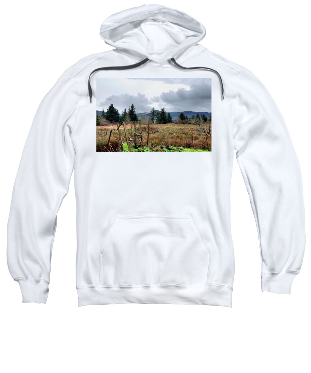 A Slight Mist Or Fog Veils Parts Of Distant Hills Beneath Troubled Skies. Sweatshirt featuring the photograph Field, Clouds, Distant Foggy Hills by Chriss Pagani
