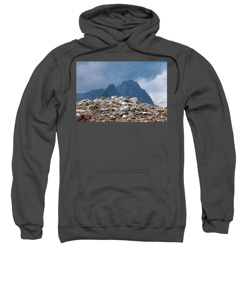 Mountains Sweatshirt featuring the photograph Stony hill with plants in front of a mountain range. by Bernhard Schaffer