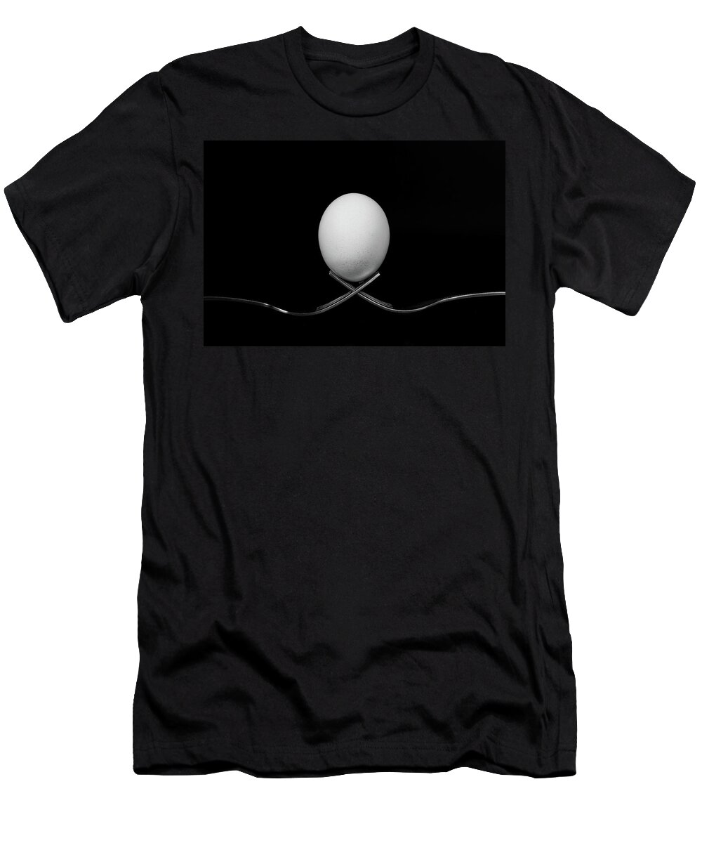 Egg T-Shirt featuring the photograph White egg resting on two metal and shiny forks on a black backg by Michalakis Ppalis