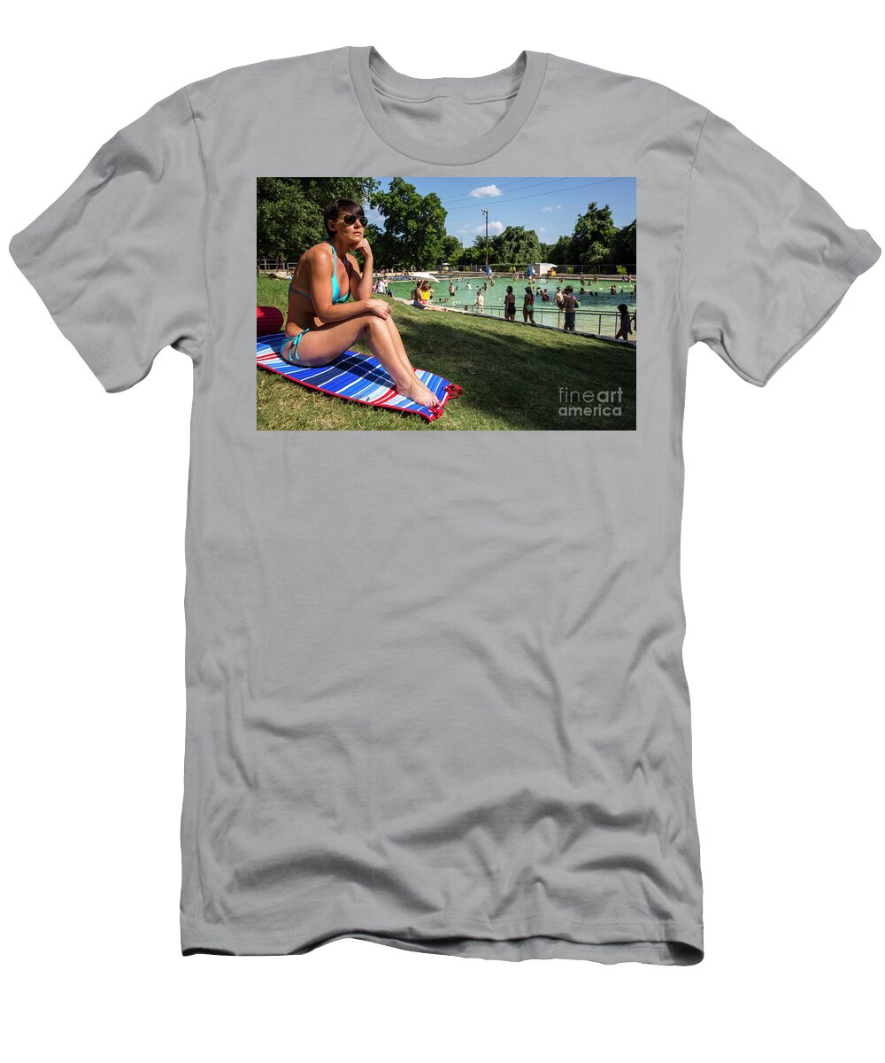Deep Eddy Pool T-Shirt featuring the photograph A fit Austin woman sunbathes in a bikini at Deep Eddy Pool, surrounded by grassy slopes which are the best in Austin for sunbathing by Dan Herron