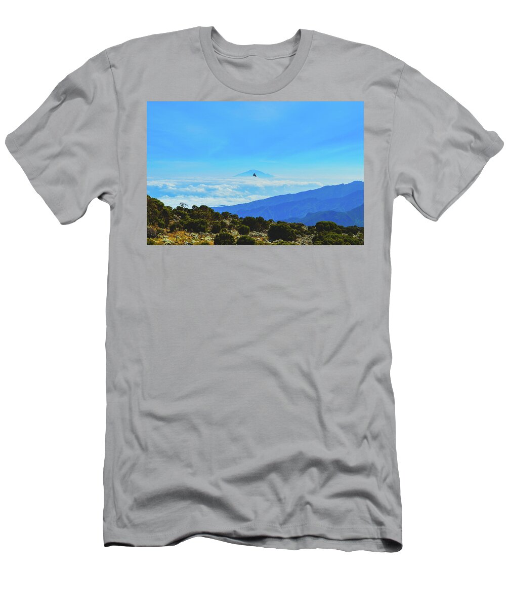 Africa T-Shirt featuring the photograph White-Necked Raven Soaring Above Mount Kilimanjaro with Mount Meru by Jeff at JSJ Photography