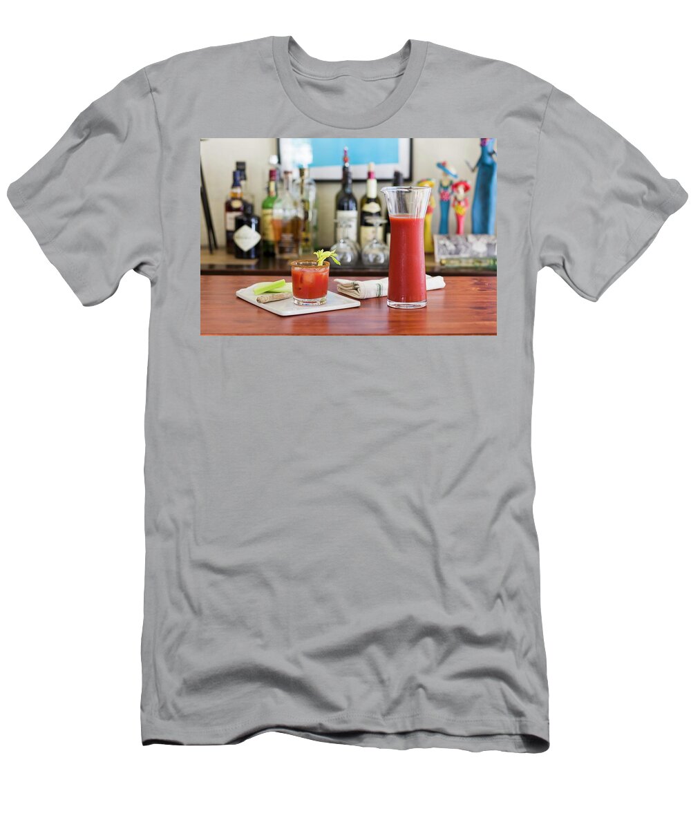 Ip_11339053 T-Shirt featuring the photograph A Classic Bloody Mary Drink With Celery On A Table With A Home Bar In The Background by Don Crossland