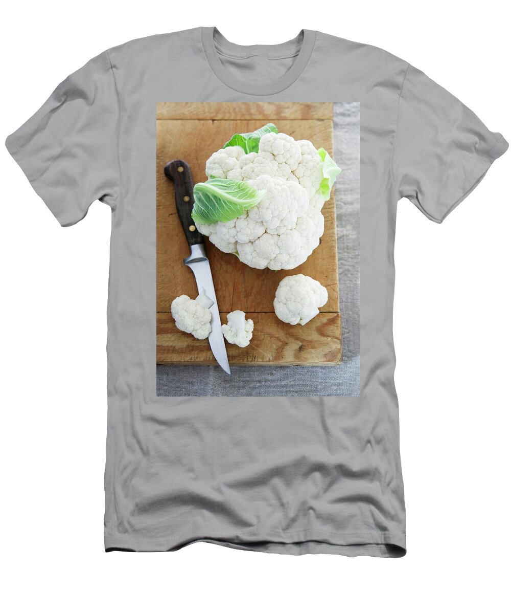 Ip_11172636 T-Shirt featuring the photograph Cauliflower And A Knife On A Chopping Board by Firmston, Victoria