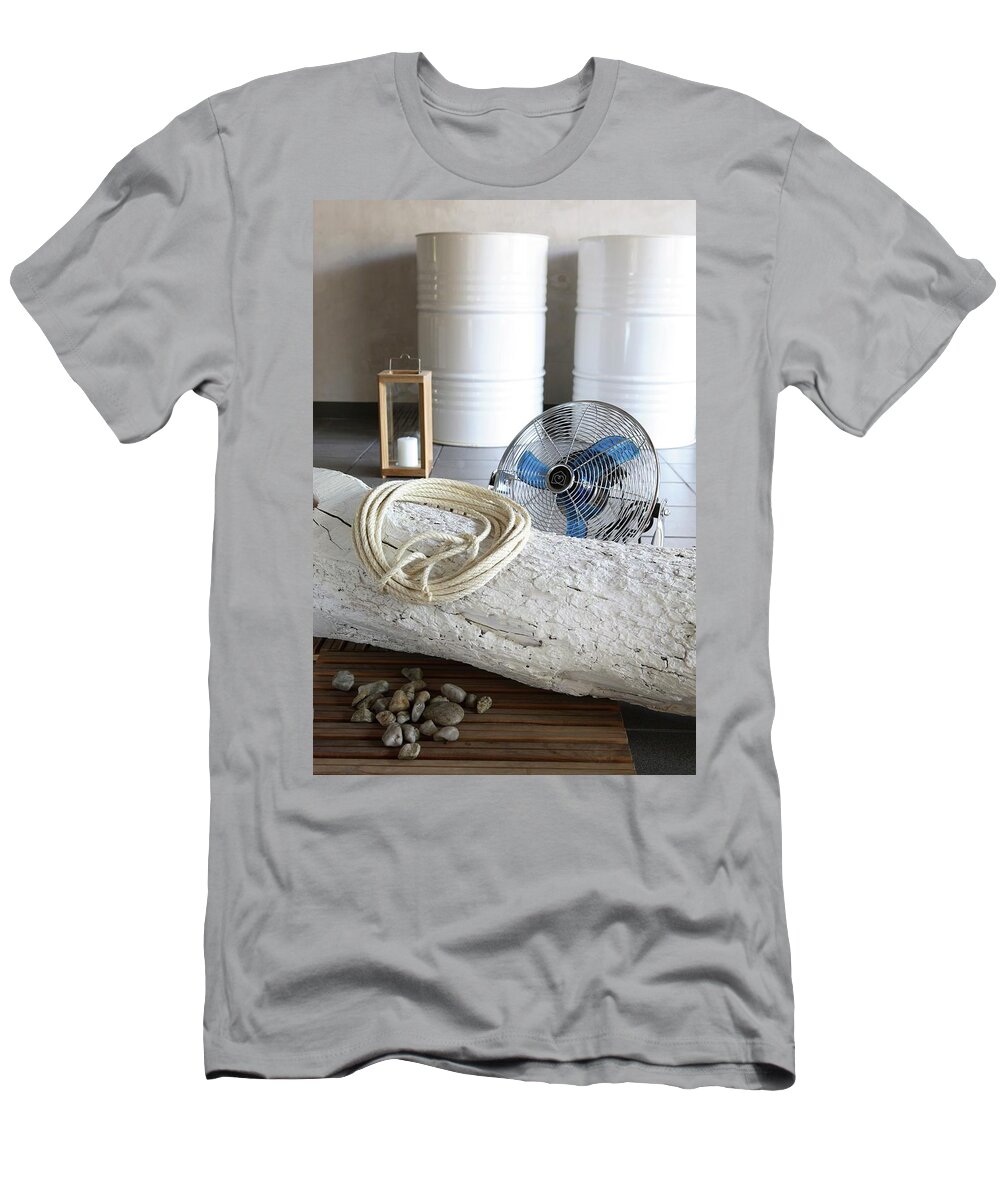 Ip_11236771 T-Shirt featuring the photograph Coiled Rope On Whitewashed Tree Trunk On Floor In Front Of Fan With White-painted Metal Drums In Background by Michal Mrowiec
