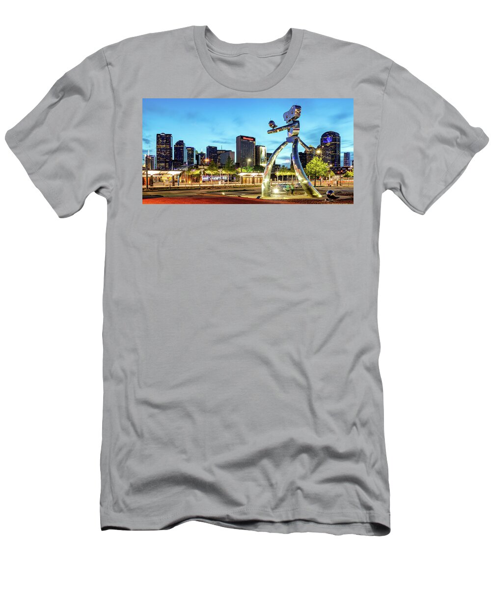 America T-Shirt featuring the photograph Dallas Skyline and Walking Tall Traveling Man Panorama at Dusk by Gregory Ballos