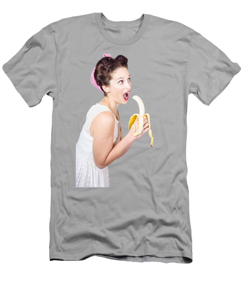 Fruit T-Shirt featuring the photograph Pin-up woman eating fruit on studio background by Jorgo Photography