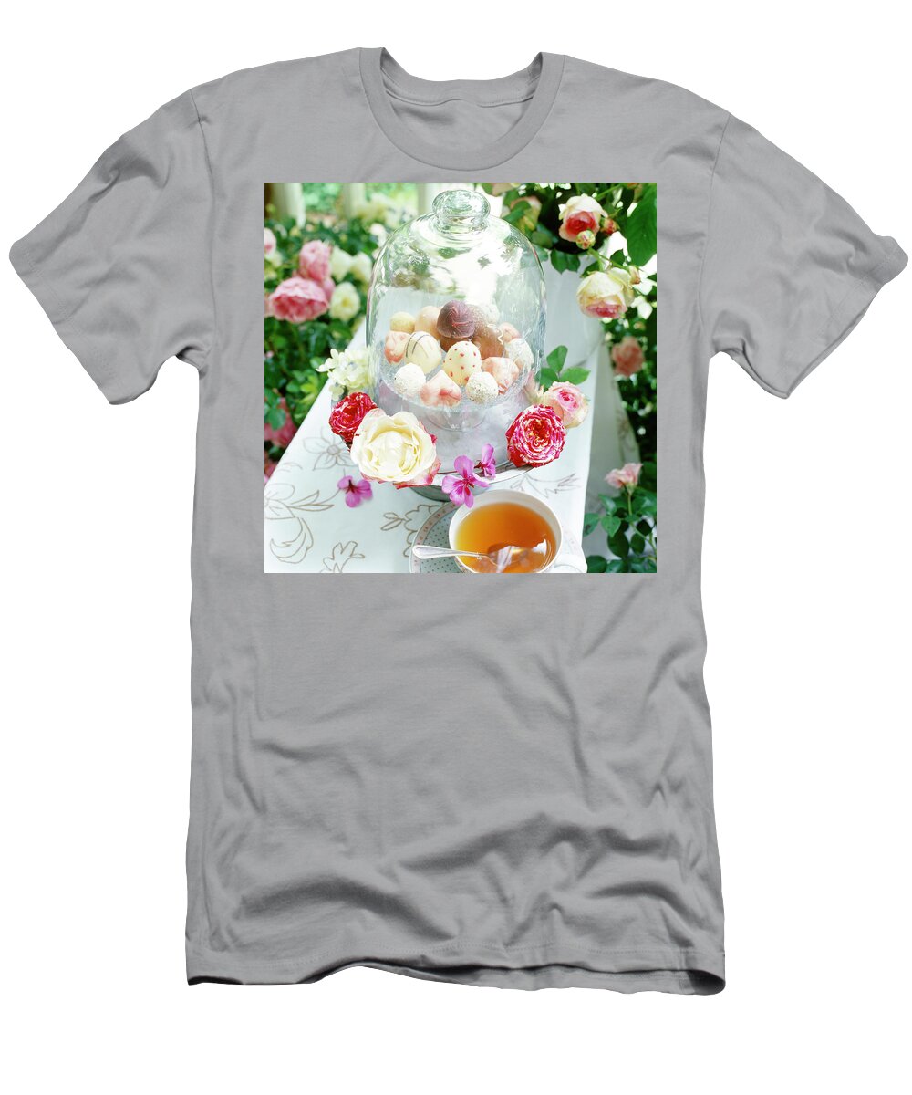 Ip_10160907 T-Shirt featuring the photograph Pralines And Dome Shaped Glass Container With Flowers On Table by Jalag / Uwe Dahlmann